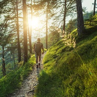 Older man walking or hiking up hill